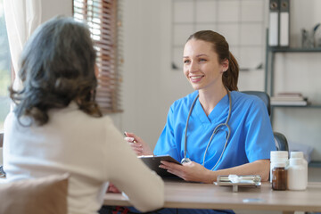 Fototapeta premium Female doctor taking a history of a patient and counseling on orthopedic diseases with female patients after measuring blood pressure and heart rate in a medical facility