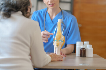 Obraz premium Female doctor taking a history of a patient and counseling on orthopedic diseases with female patients after measuring blood pressure and heart rate in a medical facility