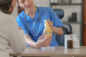 Female doctor taking a history of a patient and counseling on orthopedic diseases with female...