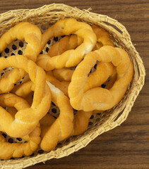 Pieces of traditional Latin American pastry called ROSQUITAS DE SAL or ROSCAS made with wheat flour. Top view of Neapolitan cookies called TARALLI. Stale salt bagels. Wood table. Ecuador