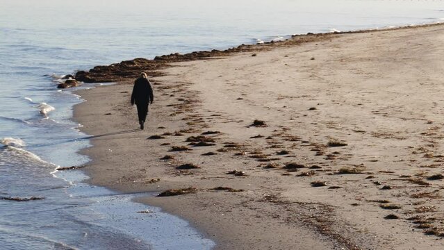 Man Walks Alone on Beach in Semaphore During a Winter Morning