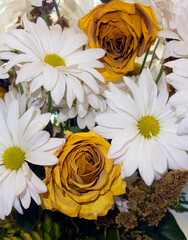 White daisies and dried yellow roses arrrangement.