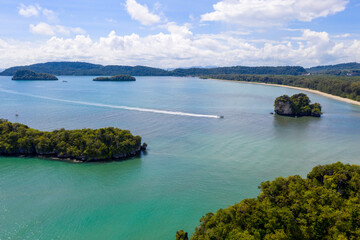 Aerial view of long tail boat passing through Ao Nang Bay on sunny day. Ao Nang, Krabi Province, Thailand.