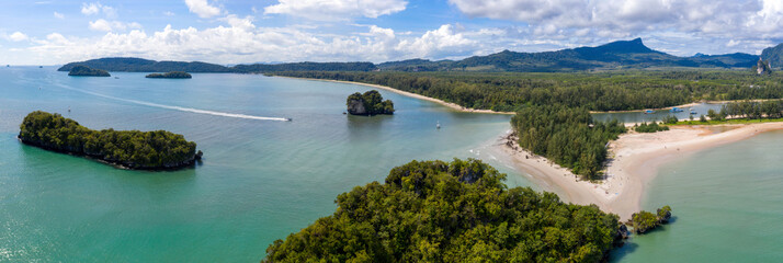 Panoramic aerial view of a long tail boat passing through Ao Nang Bay to Noppharat Thara Piers on Khlong Son river on sunny day. Krabi Province, Thailand.
