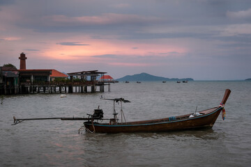 Traditional thai longtail boat and Ko Lanta Old Town at sunset, Thailand.
