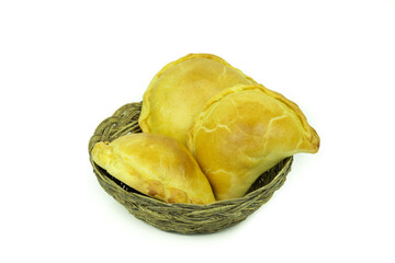 bowl of straw with empanadas on a white background. Food concept, pastry.