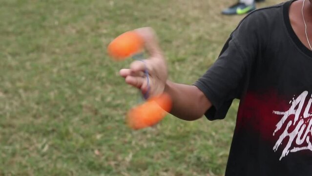 Teenagers playing Clacker Balls, also known as Latto-Latto in Indonesia. Lato lato