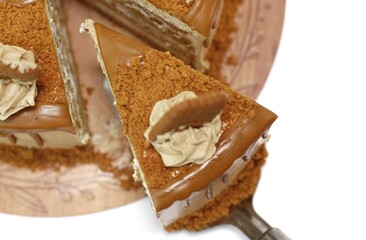 took a piece of caramel biscoff cake. Biscoff layer cake isolated on white background. copy space.