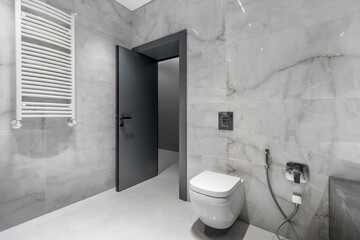 Naklejka na ściany i meble A simple modern gray wall with a black and gray door in an empty room. Interior design element of modern interior design in a modern house