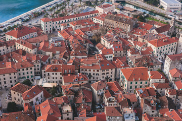 Fototapeta na wymiar Kotor, Montenegro, beautiful top panoramic view of Kotor city old medieval town seen from San Giovanni St. John Fortress, with Adriatic sea, bay of Kotor and Dinaric Alps mountains in a sunny day