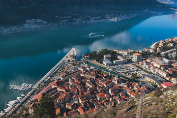 Kotor, Montenegro, beautiful top panoramic view of Kotor city old medieval town seen from San Giovanni St. John Fortress, with Adriatic sea, bay of Kotor and Dinaric Alps mountains in a sunny day