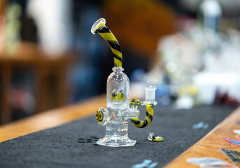 a closeup of a yellow and black glass bong used for recreational cannabis