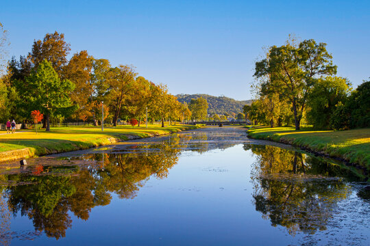 Creek flowing through park lands in a town