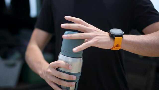 Detail image of hand and clock opening thermos
