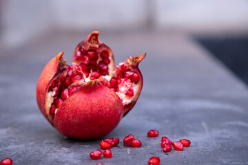 ripe pomegranate fruit with seeds on a gray background