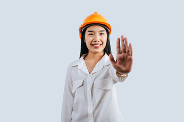 Woman engineer with hardhat and open hand doing stop sign posture