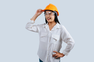 Young female engineer wearing yellow helmet stand with charming smile posture