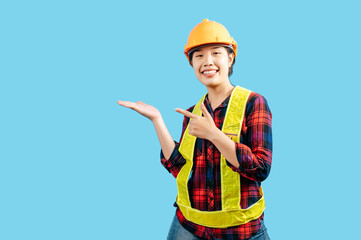 Young female engineer wearing yellow helmet with point finger posture