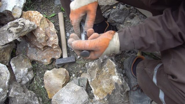 Man Carving Stone with Hammer and Chisel