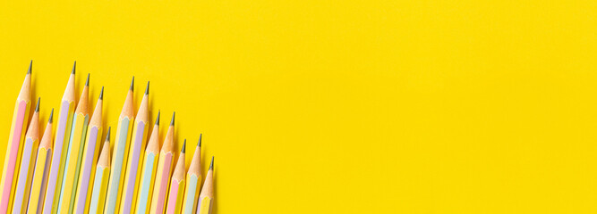 Wooden pencil on yellow background,Templates with copy space by the macro image in the upper corner of the yellow wooden pencil Placed on a clean, minimal looking yellow paper, the side strobe lights 