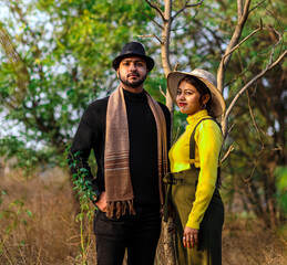 Fototapeta premium Pre wedding shot of an Indian couple in Nature's trail in Delhi, India. Romantic couple Shoot. Bride and groom in the natural forest of with trees. Mountain wedding Forest wedding Wedding photo shoot.