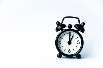 Black alarm clock pointing at 1 o'clock with customizable space for text on white background. Copy space and time concept.