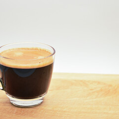 glass of hot black coffee put on wood background