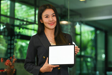 Portrait of Asian Mature Businesswoman wearing casual suit holding tablet computer and showing blank screen, Success working concept.