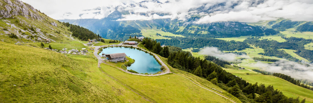 Panorama aerial image of the mountain lake Haerzlisee above the Engelberg in Titlis region, which offers diverse outdoor activities, such as hiking, climbing, skiing.