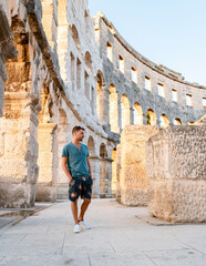 Young men tourist visit Pula city in Croatia, Roman amphi theatre Arena in Pula