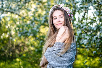 Beautiful girl with flower wreath on head. Beauty young woman with flowers hairstyle. Fashion photo.