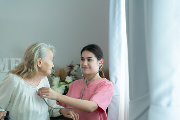 Fototapeta premium Caregiver for an elderly woman Weekly check-ups at the patient's residence. Ready to give medical advice and talk about various stories, exchange each other happily.