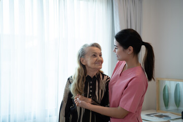 Fototapeta premium Caregiver for an elderly woman Weekly check-ups at the patient's residence. Ready to give medical advice and talk about various stories, exchange each other happily.