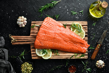 Raw salmon fillet on a wooden board. Recipe. Top view. Seafood.