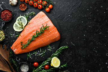 A large piece of salmon fillet on a dark kitchen table. Top view. Seafood.