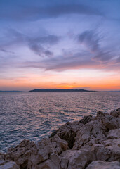 Beautiful yellow sunset on the sea. Rocky coast.
