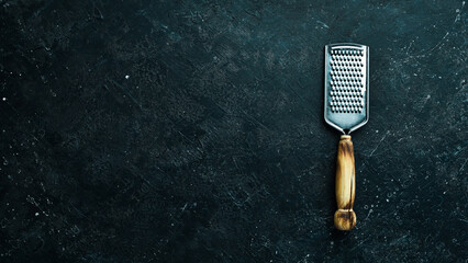 Cheese grater on a stone background. Kitchen utensils. Free space for text.