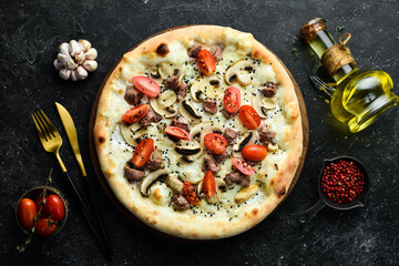 Delicious homemade pizza with veal and mushrooms. Home delivery of food. On a black stone background.