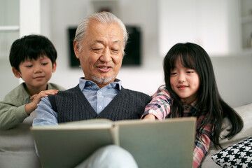 asian grandpa and two grandchildren having a good time at home