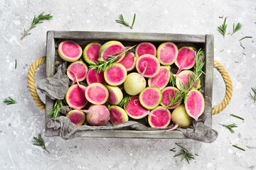 Radish watermelon in a box. Healthy vegetables, diet food. Free space for text, on stone background.