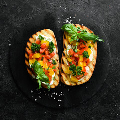 Vegan Sandwich with sweet peppers, cheese, vegetables and basil. Bruschetta. Top view. On a stone background.