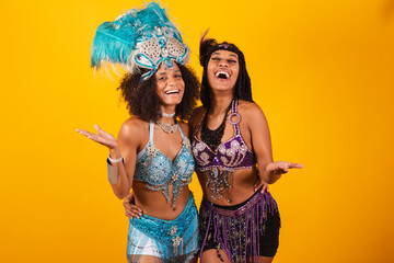 two Brazilian women friends, in carnival clothes. inviting hands.