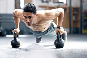 Obraz na płótnie Canvas Fitness, push up or man with kettlebell for training, body workout or exercise at health club studio. Motivation, mindset or healthy Indian sports athlete exercising with focus or resilience at gym