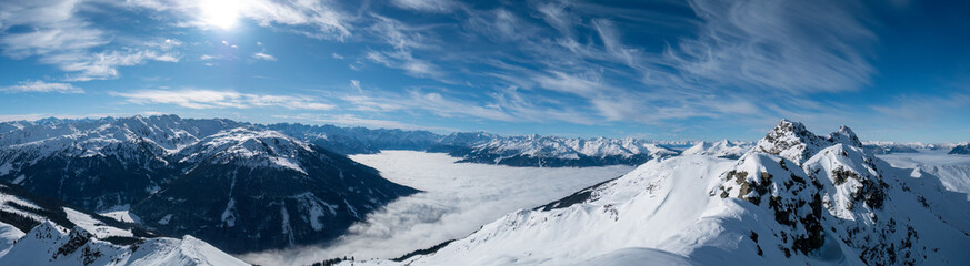 Winterpanorama Zillertal im Nebel mit umliegenden Bergen in der Sonne