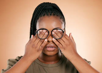 Hands, eyes and glasses with a black woman in studio on a beige background covering her face....