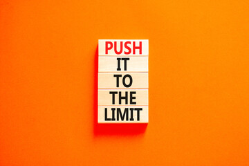 Push it to the limit symbol. Concept words Push it to the limit on wooden blocks. Beautiful orange table orange background. Business push it to the limit concept. Copy space.