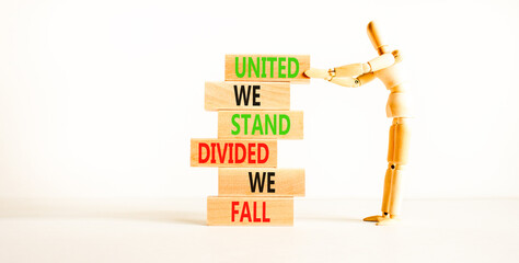 United or divided symbol. Concept words United we stand divided we fall on wooden blocks. Beautiful white table white background. Businessman icon. Business united or divided concept. Copy space.
