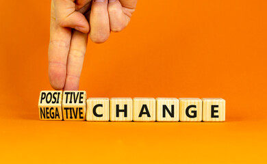 Positive or negative change symbol. Concept word Positive change Negative change on wooden cubes. Beautiful orange background. Businessman hand. Business positive negative change concept. Copy space