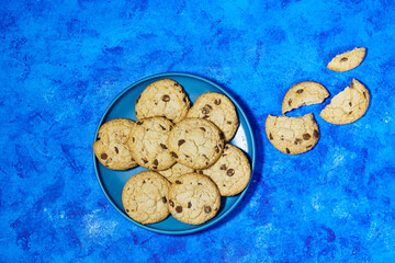 homemade chocolate chip cookies in plate on blue grunge background