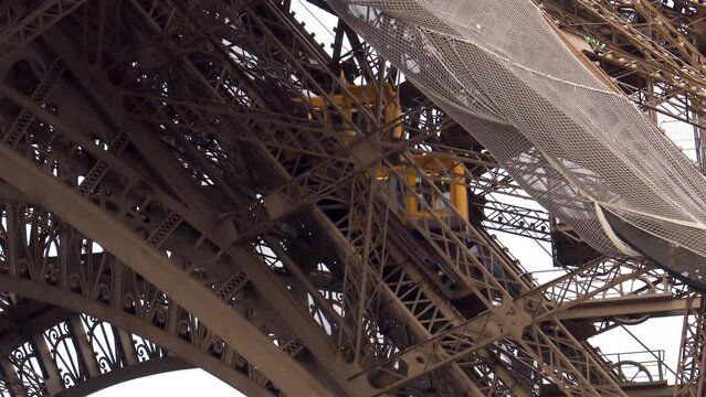 Yellow elevator going up in the Eiffel Tower in Paris, France
